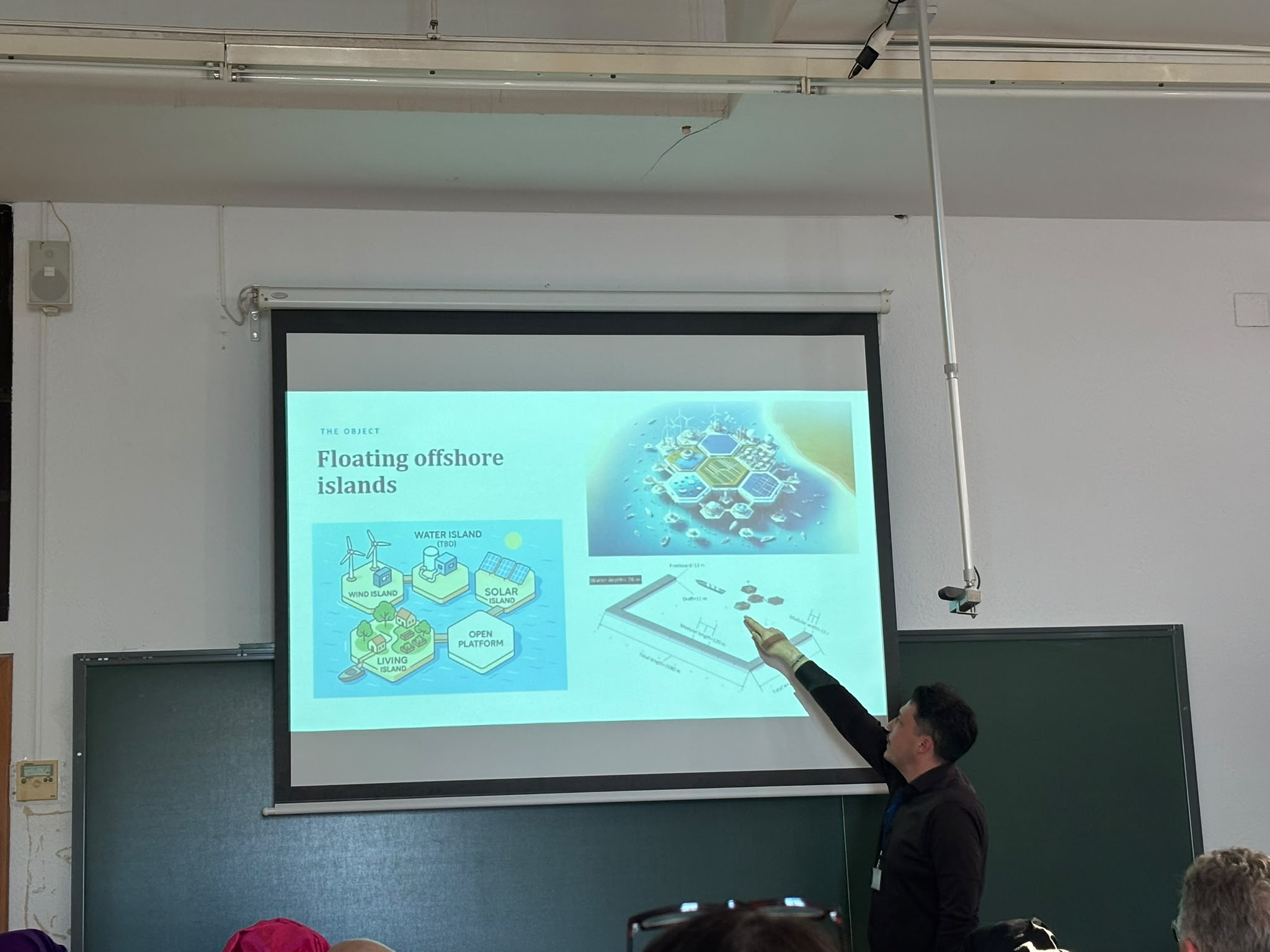 A presenter pointing to a slide on floating offshore islands during a conference session